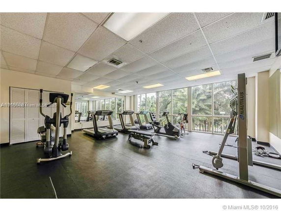 Indoor gym area with various fitness equipment and large windows.