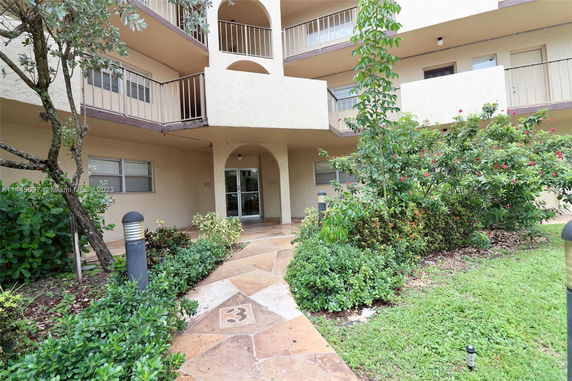Front view of a multi-story building with balconies and an entrance.