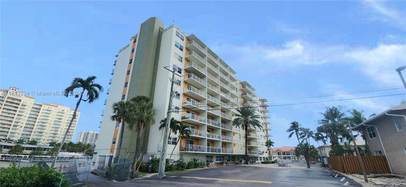 Front view of a multi-story residential building with balconies.
