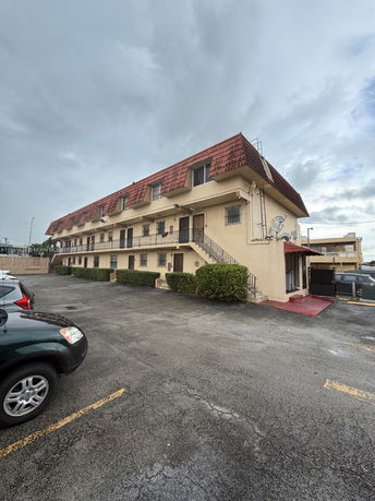Front view of a multi-story building with a sloped roof.