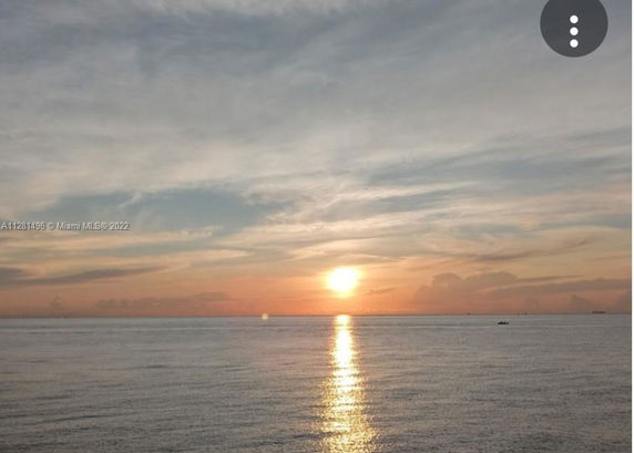 Panoramic view of a sunset over the ocean with a colorful sky.