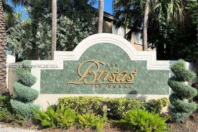Signage for Las Brisas at Doral with decorative plants around.