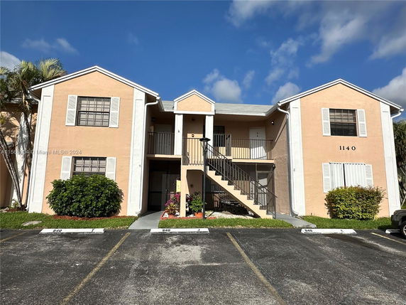 Front view of a two-story building with an exterior staircase.