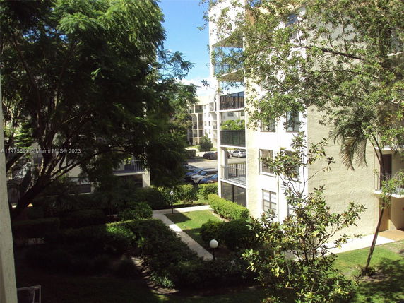 View of residential buildings surrounded by trees and greenery.