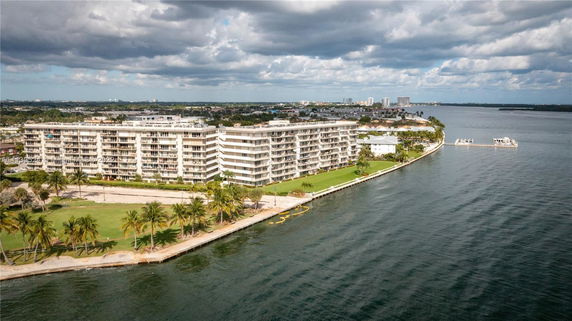 Aerial view of a waterfront residential building complex near the shoreline.