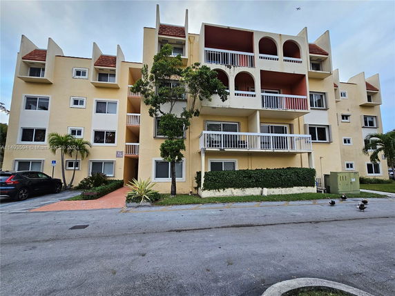 Front view of a multi-story residential building with balconies.