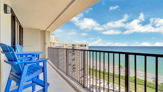 Balcony view overlooking the ocean and surrounding buildings.