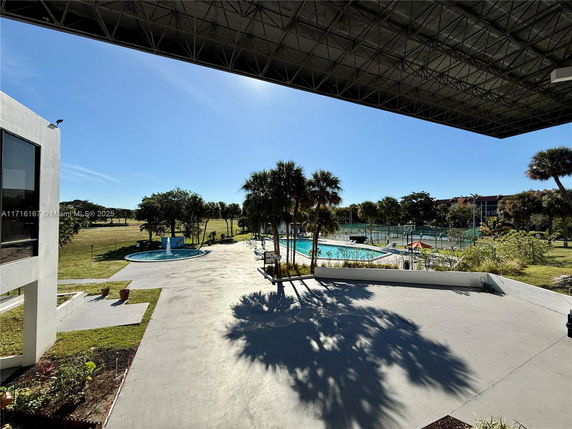 View of an outdoor area with a swimming pool and surrounding greenery.