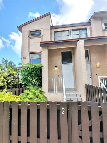 Front view of a two-story house with a fenced entrance.