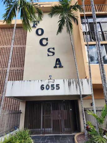 Front view of a multi-story building with large letters and numbers on the facade.