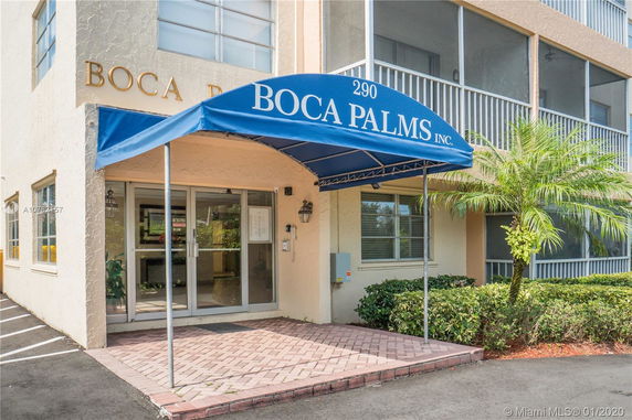 Front view of a building with a blue awning and glass entrance doors.