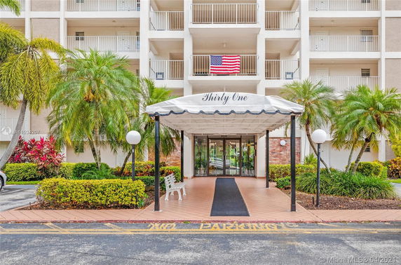 Front view of a multi-story residential building with balconies and an entrance canopy labeled 'Thirty One'.