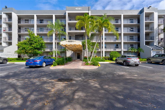 Front view of a multi-story building with balconies and entrance canopy.