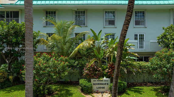Front view of a multi-story building with green roof and balcony.