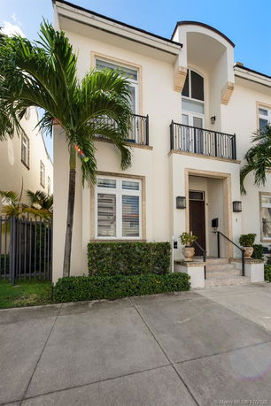 Front view of a two-story house with a balcony and a modern entrance.