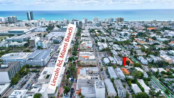 Aerial view of a cityscape with buildings and roads extending towards the ocean.