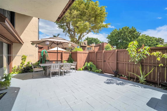 Outdoor patio area with seating and umbrella adjacent to a building.