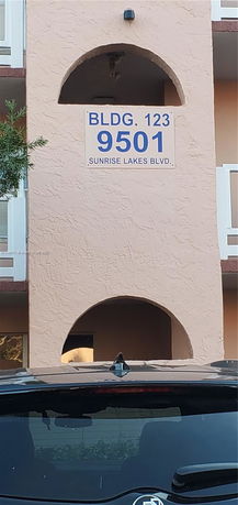 Front view of a building featuring an archway and a sign for BLDG. 123.