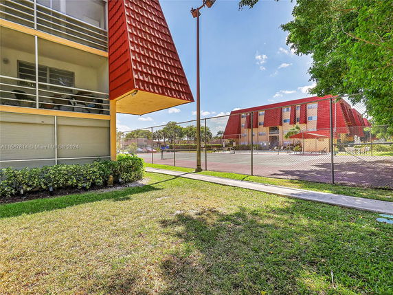View of a building with an adjacent area enclosed by a fence, possibly for outdoor activities.