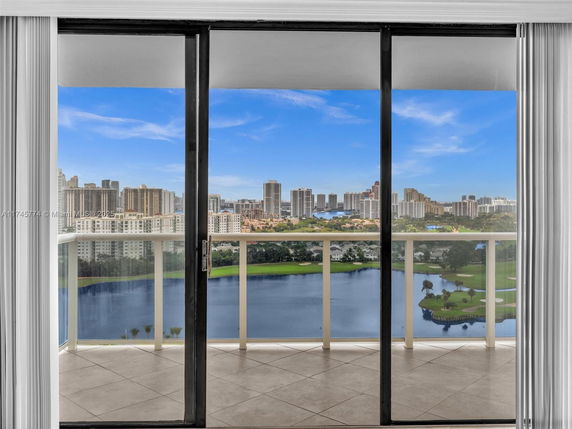 View through glass doors showing a city skyline and water body.