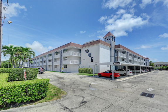 Front view of a multi-story building with covered parking.