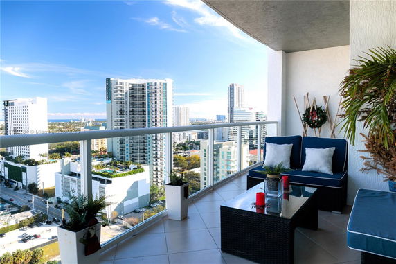 Outdoor balcony with seating and view of surrounding city skyline.
