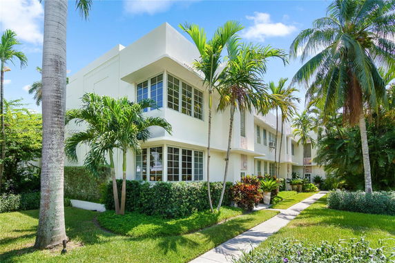Front view of a two-story modern house with large windows and palm trees.