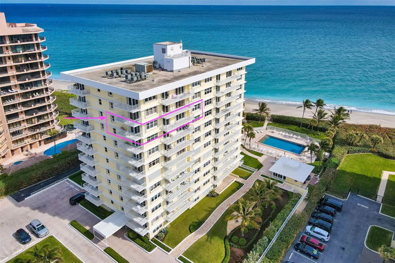 High-rise apartment building near the ocean, with a rooftop containing air conditioning units.