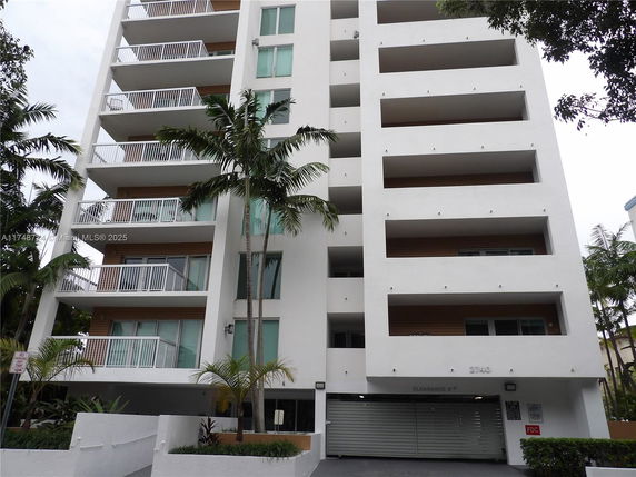 Front view of a multi-story apartment building with balconies.