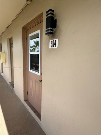 View of a building facade showing a door with number 304 and an exterior light fixture.