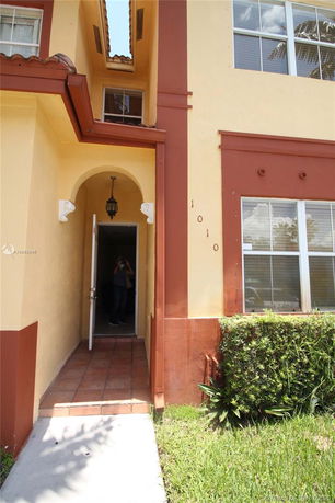 Front view of a two-story house with an open entrance and a small porch area.