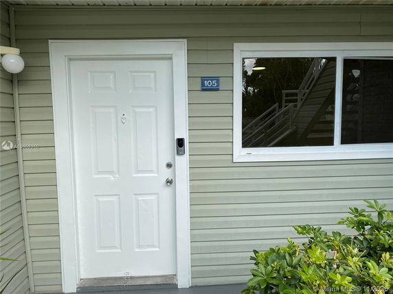 Front view of a building entrance with a white door and a window.