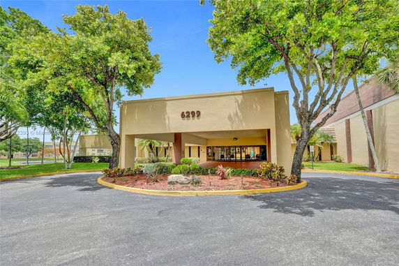 Front view of a building with a drive-through entrance and prominent address number 6299.