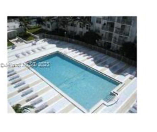 Rooftop view featuring a large swimming pool with surrounding lounge chairs.