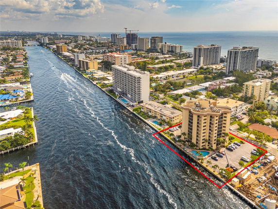 Aerial view of a coastal residential area with high-rise buildings and a waterway.