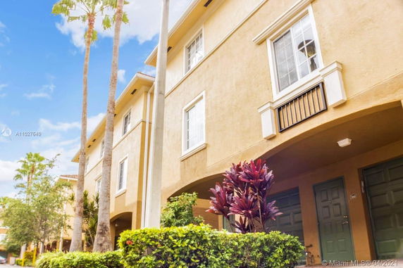 Front view of a multi-story residential building with arched entrance and decorative windows.