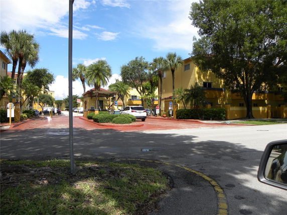 View of surrounding area with buildings and palm trees.