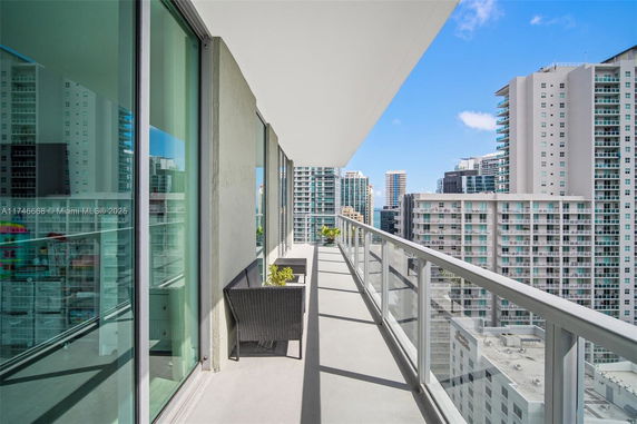 Balcony view overlooking a cityscape with multiple high-rise buildings.