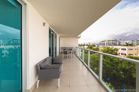View from a balcony with glass railing overlooking residential buildings.