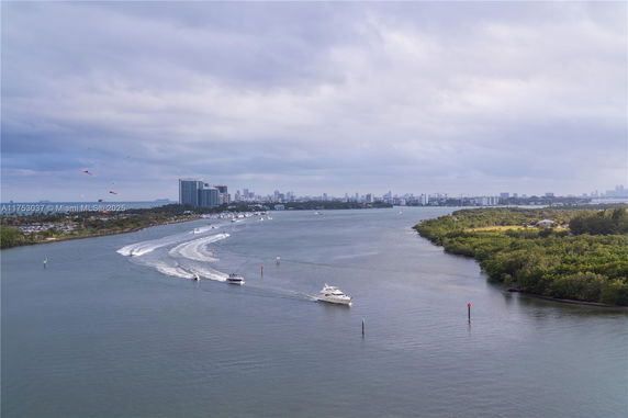 Panoramic view of a river with boats and a distant cityscape.