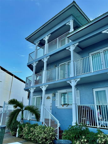 Front view of a multi-story building with balconies and blue exterior.