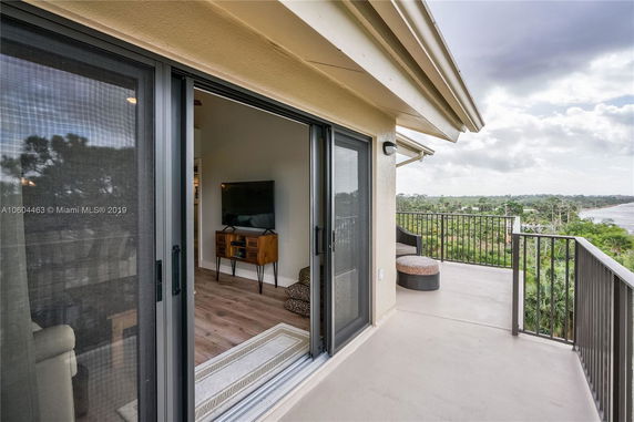 Balcony view with railing overlooking a scenic landscape and body of water.