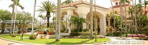 Front view of a building with arched entryways and tropical landscaping.