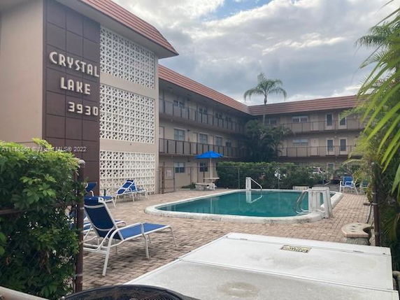 Outdoor swimming pool area in the courtyard of a multi-story residential building.
