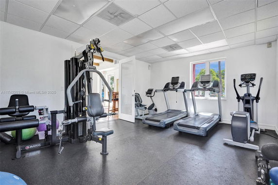 Room with gym equipment including treadmills and a multi-station exercise machine.