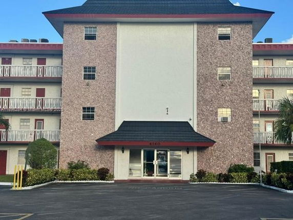 Front view of a multi-story residential building with a central entrance.