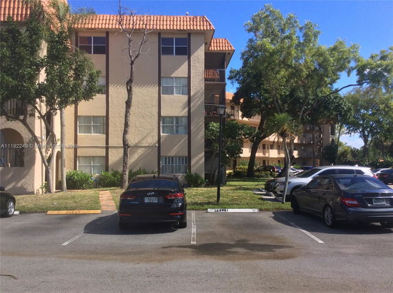 Outdoor parking area in front of a multi-story residential building.