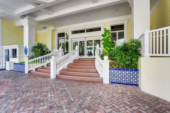 Front view of a building entrance with steps leading up and decorative railings.