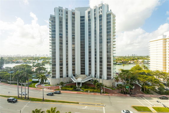 Front view of a multi-story residential building with numerous balconies.