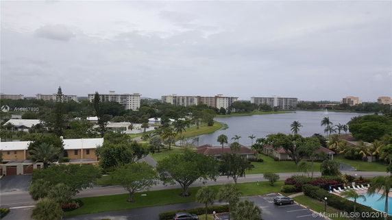 View of a residential area with multi-story buildings and a lake.